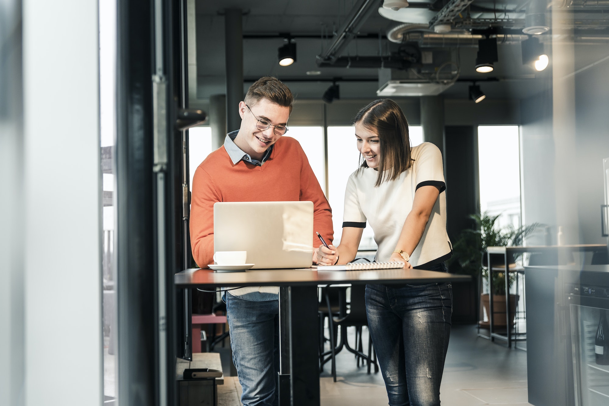 Casual businessman and woman with laptop meeting in office-letsworkabroad